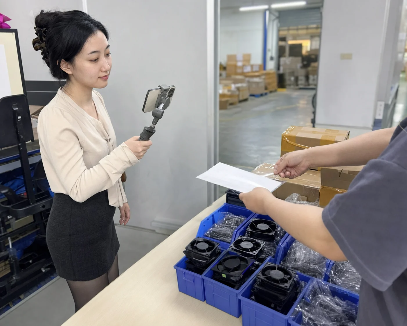 自媒体拍摄人员记录散热风扇样品与仓库批次交接的手机场景