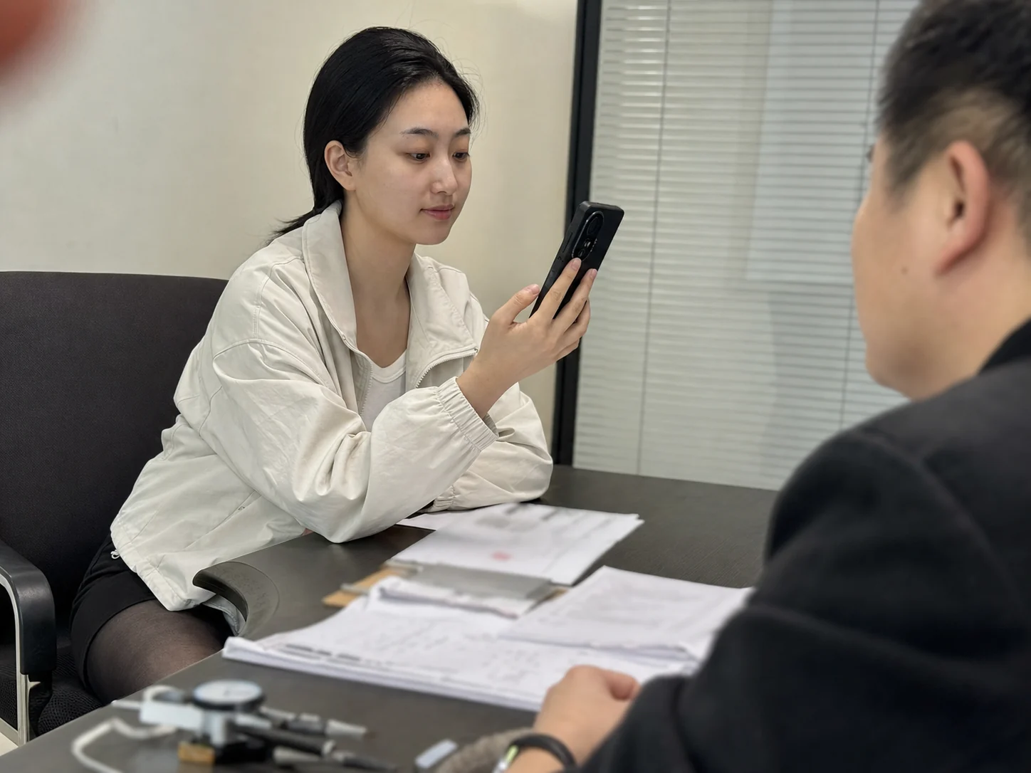 自媒体拍摄人员记录游标卡尺加工需求与供应商资料讨论的手机场景